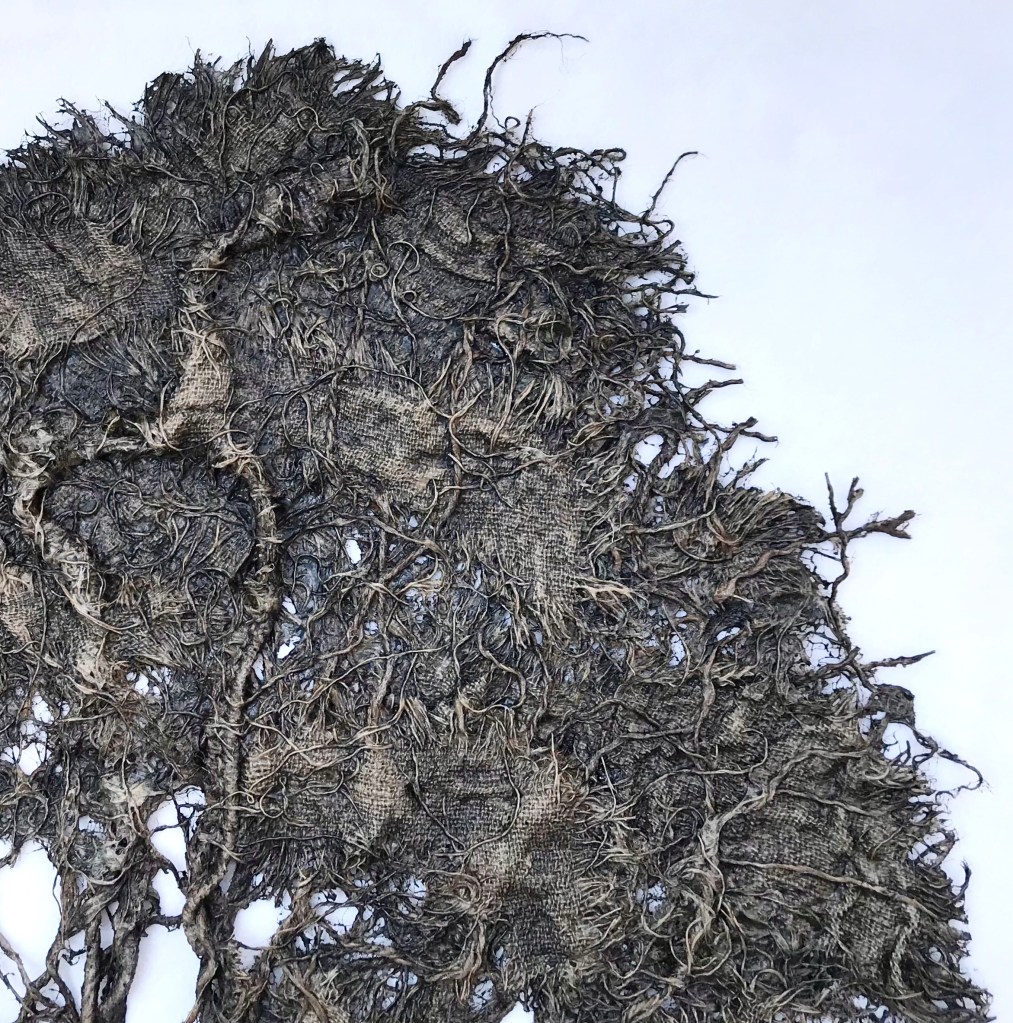 Detail of an abstract fabric sculpture by MJ Seal that resembles a giant, dark gray sea fan