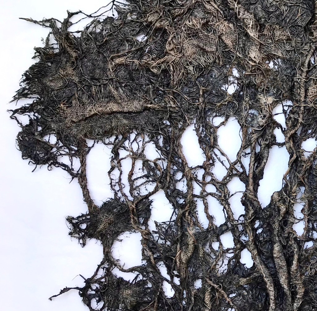 Detail of an abstract fabric sculpture by MJ Seal that resembles a giant, dark gray sea fan