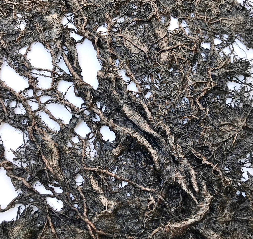 Detail of an abstract fabric sculpture by MJ Seal that resembles a giant, dark gray sea fan