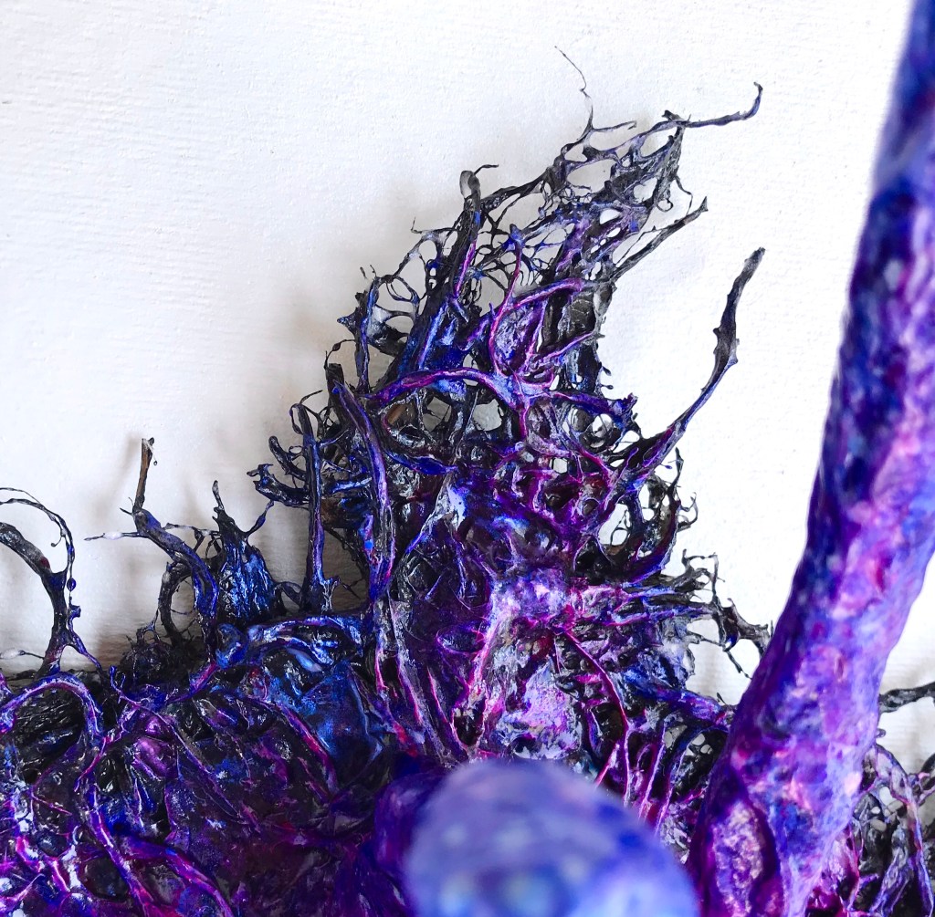 Detail of an abstract paper mache sculpture by MJ Seal that resembles an iridescent octopus reaching through a wall