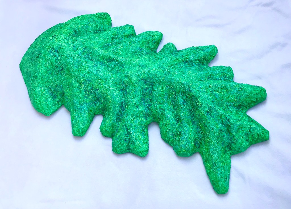 Full view of an abstract paper mache by MJ Seal that resembles a cross between a mountain and a primitive sea creature with green reptilian skin